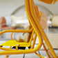 Yellow kids patio swing chair with adjustable canopy and safety belt, close-up frame