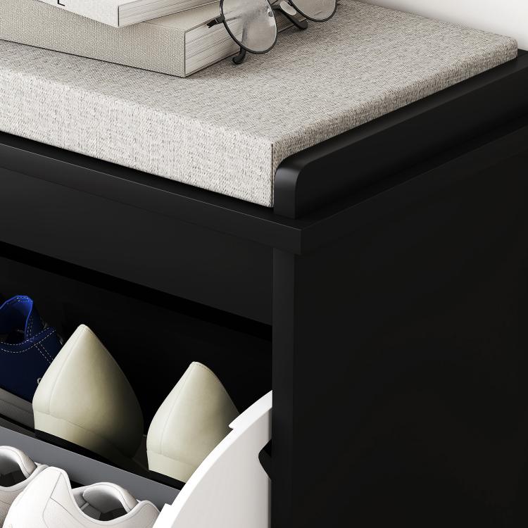 Black shoe storage bench with gray padded seat and open flip drawer holding shoes