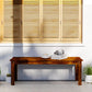 Backless wood bench with slatted seat and dark brown finish against a wall