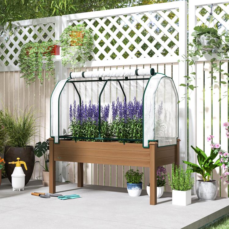 Raised garden bed greenhouse cover with mesh walls, brown frame, green plants and purple stems