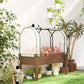 Raised garden bed with greenhouse cover, brown frame, pink flowers inside mesh
