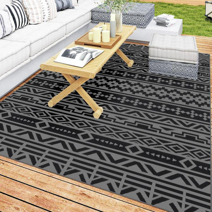 Reversible outdoor rug with black and gray geometric pattern, flat woven look