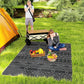 Black and gray outdoor rug with geometric pattern under a picnic setup on grass