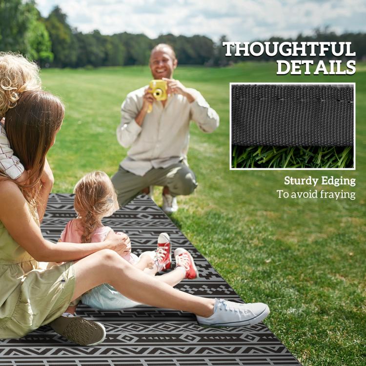 Black and gray geometric outdoor rug with sturdy stitched edging for safe, flat lay