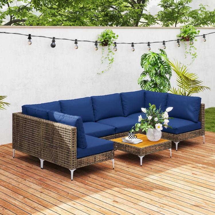 Brown wicker modular patio sectional with thick blue cushions and glass-top coffee table