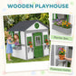White wooden playhouse with green door plus flower planter boxes and pot holder ledges