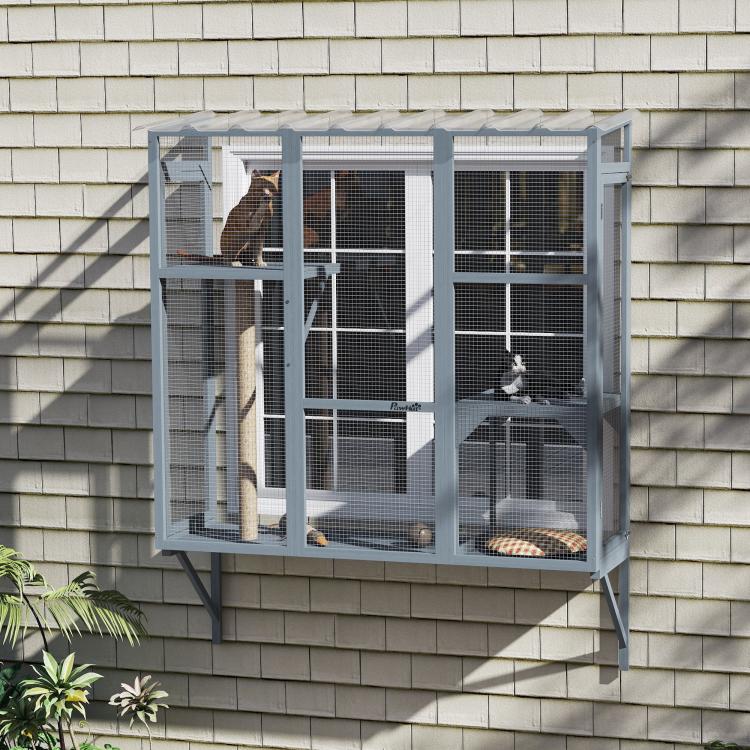 Gray window catio on house siding with cats inside, platforms, and scratching post