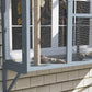 Gray window catio door with mesh panels, showing cats resting inside