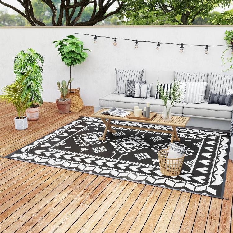 Outdoor reversible rug with black and white geometric patchwork design