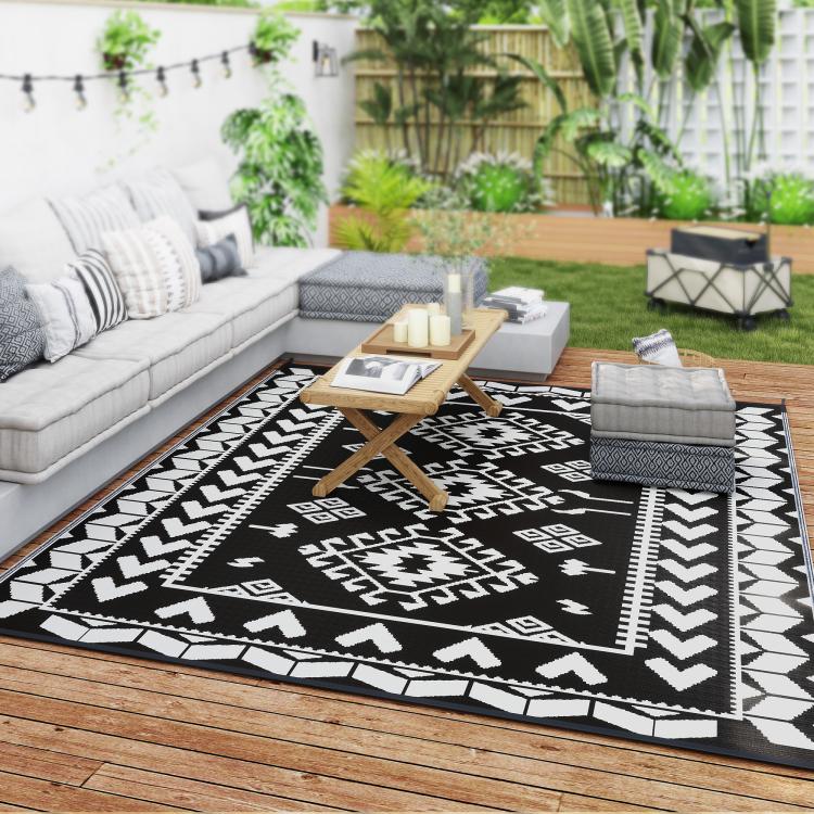 Outdoor reversible rug on a deck with black and white geometric pattern