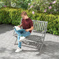 Gray outdoor bench with slatted seat and backrest in a garden patio setting