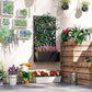 Black metal raised planter box with privacy screen and assorted flowering plants