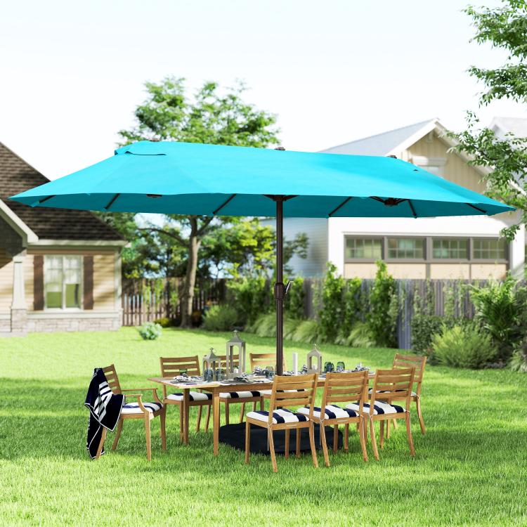 Blue outdoor market umbrella over backyard dining set on a lawn