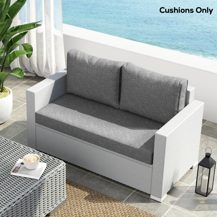 Gray outdoor loveseat cushion set with two back cushions on a white frame