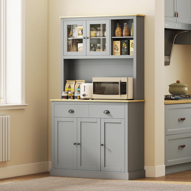 Gray freestanding pantry cabinet with glass upper doors, open microwave shelf, and two storage doors