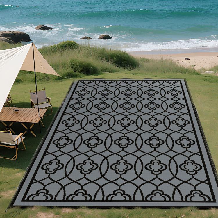 Reversible outdoor rug with black border and gray quatrefoil pattern