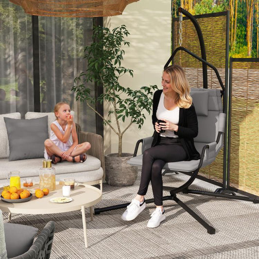 Gray hammock swing chair with padded seat and back, on a black steel stand