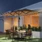Khaki patio umbrella with LED lights over outdoor dining table and chairs