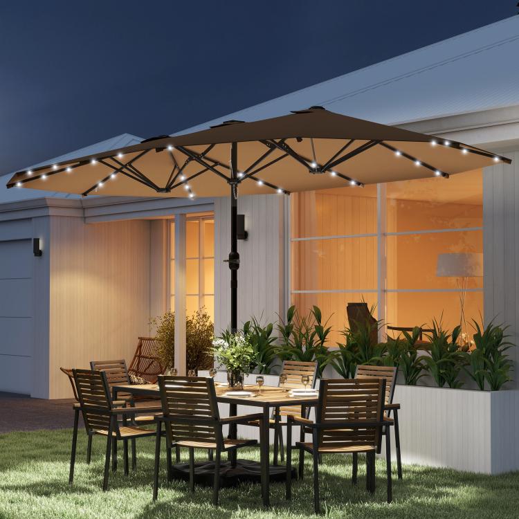 Khaki patio umbrella with LED lights over outdoor dining table and chairs