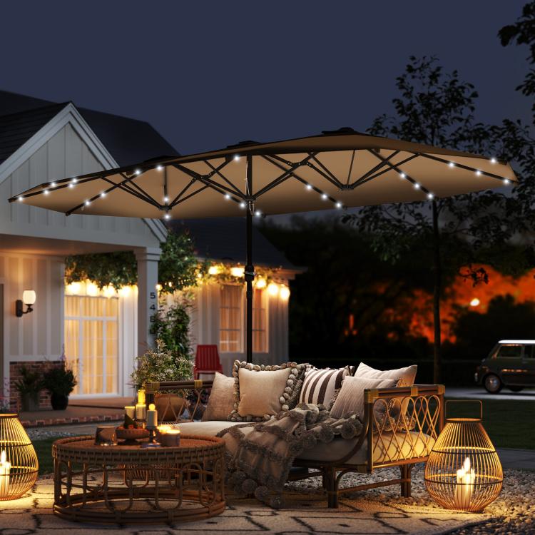 Khaki patio umbrella with LED lights over outdoor lounge seating at night