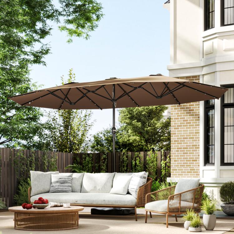 Khaki patio umbrella open over outdoor sofa seating near the house
