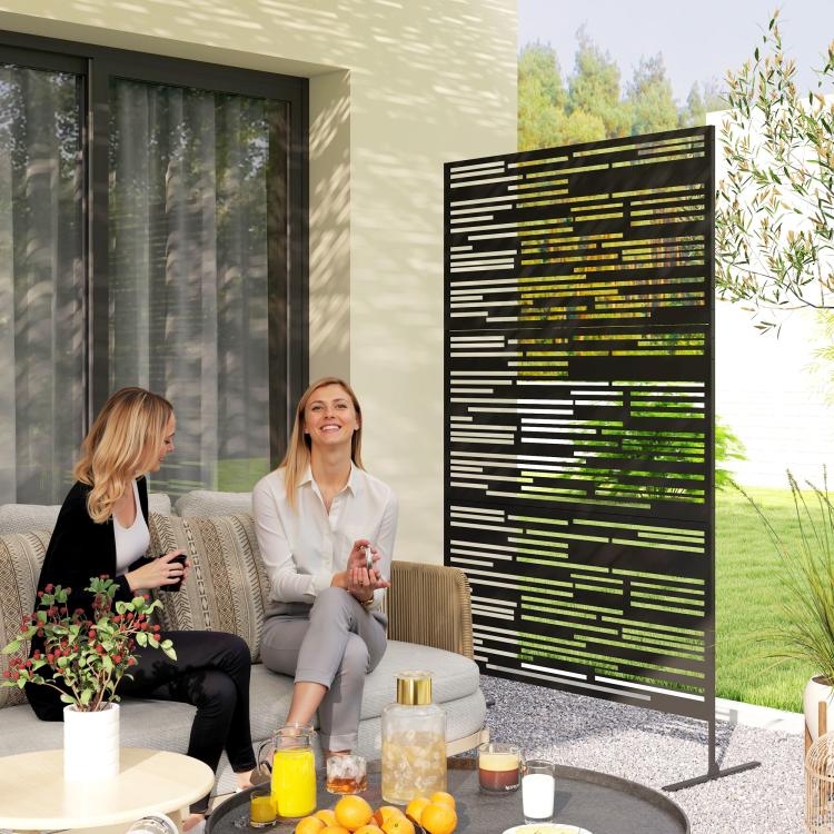Black metal privacy screen with rectangular cutout pattern, freestanding on legs