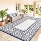 Blue and white reversible outdoor rug with navy gourd border and central cream panel
