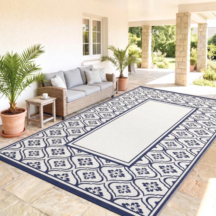 Blue and white reversible outdoor rug with navy gourd border and central cream panel