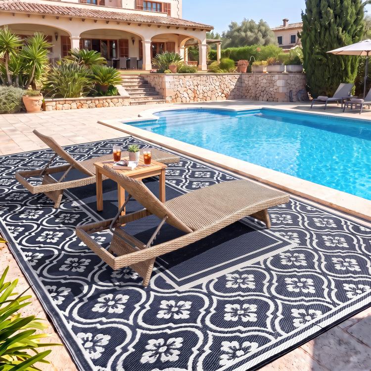 Outdoor rug with navy-and-white gourd border beside swimming pool deck