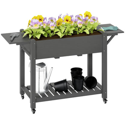 Gray wooden raised planter box with side tables, lockable wheels, and bottom shelf for pots
