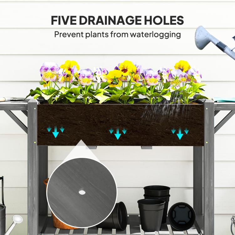 Raised planter box interior showing drainage holes above pots on bottom shelf