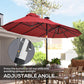 Wine red patio umbrella with adjustable tilt angle and LED light detail on canopy ribs
