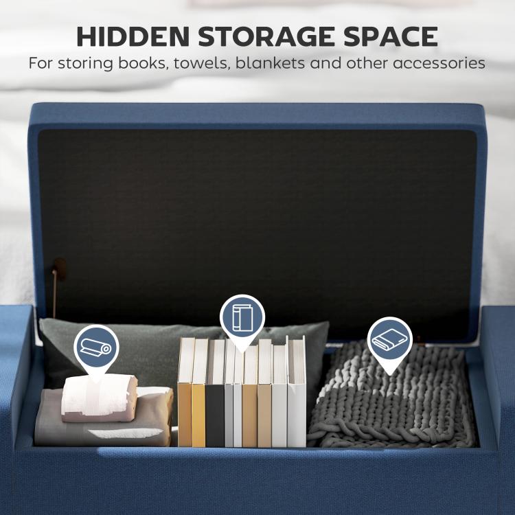 Dark blue storage ottoman with lid open to reveal hidden compartment for blankets