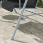 Outdoor porch swing with dark seat cushions and canopy support frame