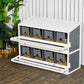 White outdoor chicken nesting box with dark compartments, perches, and front access shelves