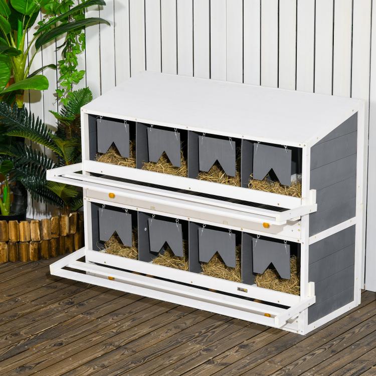 White outdoor chicken nesting box with dark compartments, perches, and front access shelves