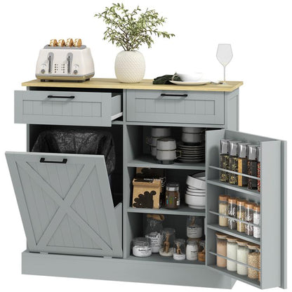 Gray farmhouse kitchen cabinet with tilt-out hidden trash can and two drawers, open storage doors.