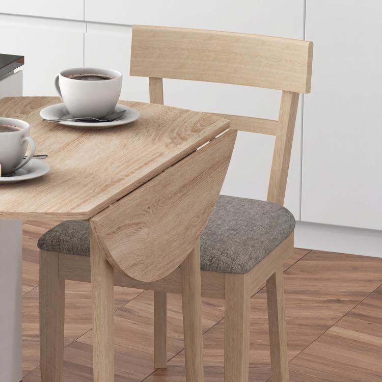 Oak round drop-leaf dining table with wooden legs and one leaf extended