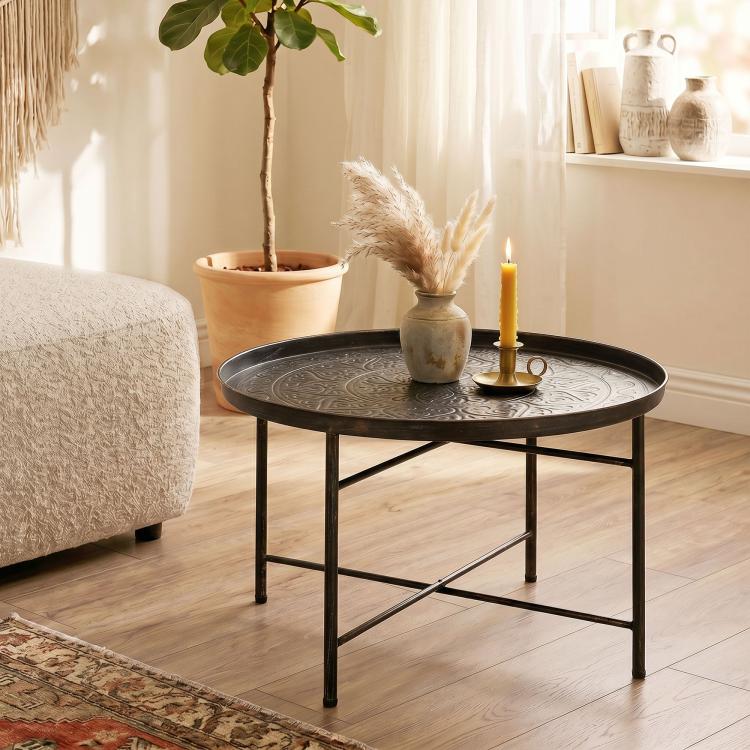 Round coffee table with hammered tray top and black metal frame, pewter tone