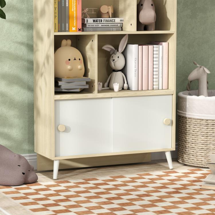 Close-up of kids storage shelf: open cubbies with books and plush animals, white doors