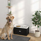 Pet feeding station with two metal bowls and storage drawer, in use with a yellow dog
