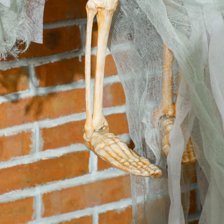 White tattered hanging ghost prop with long fabric legs and orange pumpkin face hood