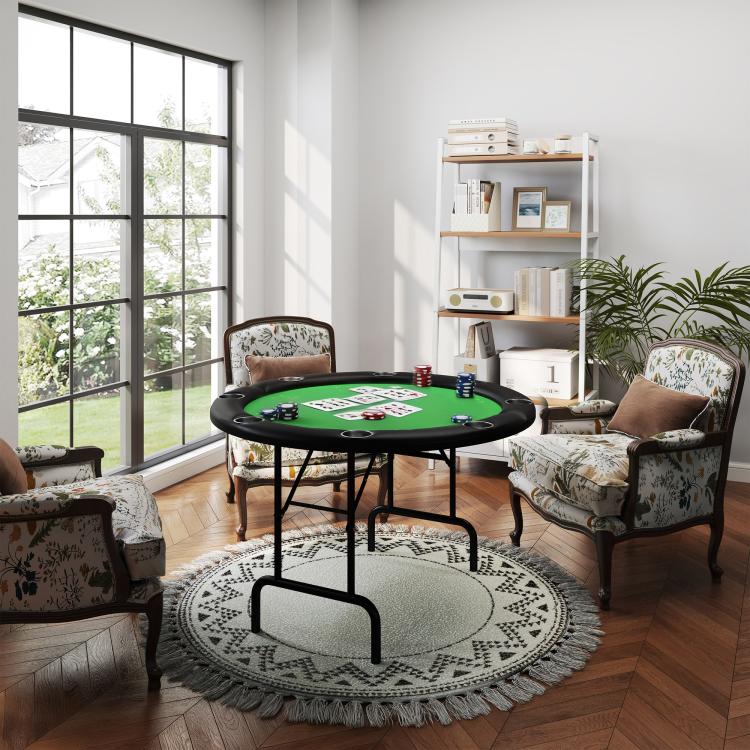 Round poker table with green felt on black legs, near upholstered seating