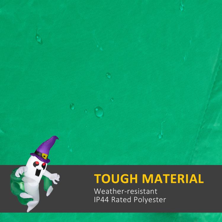 Inflatable Halloween ghost on green fabric background, purple hat and black eyes