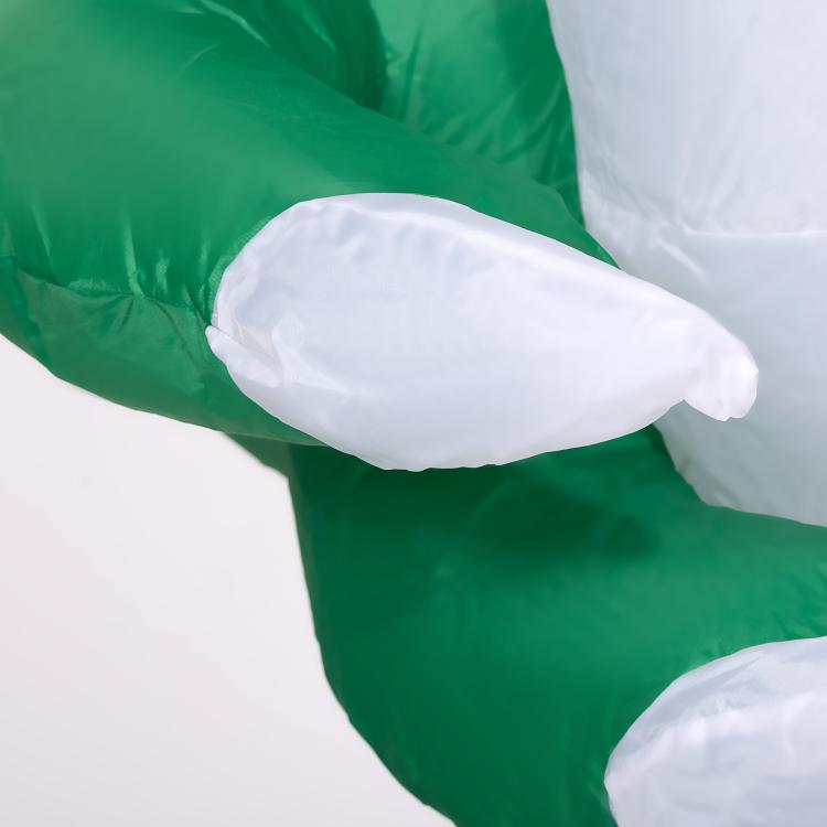 Close-up of inflatable ghost white body and arm over green fabric, Halloween decor