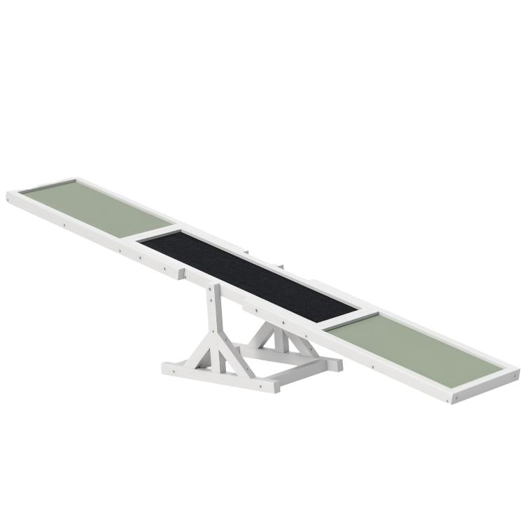 White wooden dog agility seesaw with green and black textured panels, raised center