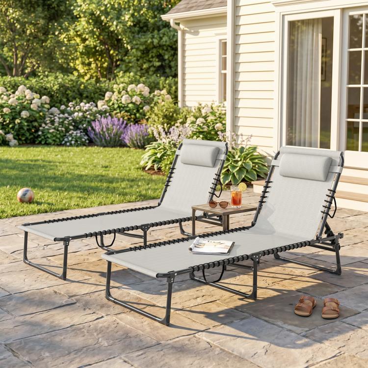 Two dark-frame reclining folding chaise lounge chairs with padded headrests and bungee mesh seats