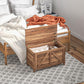 Lift-top storage chest with lid open, holding folded linens inside, brown wood grain