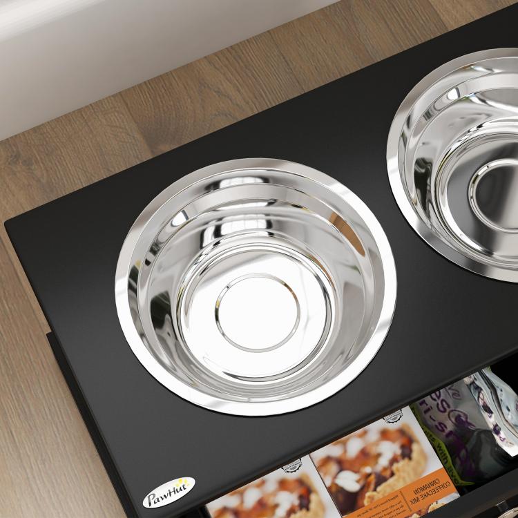 Close-up of stainless steel dog bowl on black raised stand with drawer contents