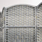 Close-up of rounded top panel on gray woven folding privacy screen